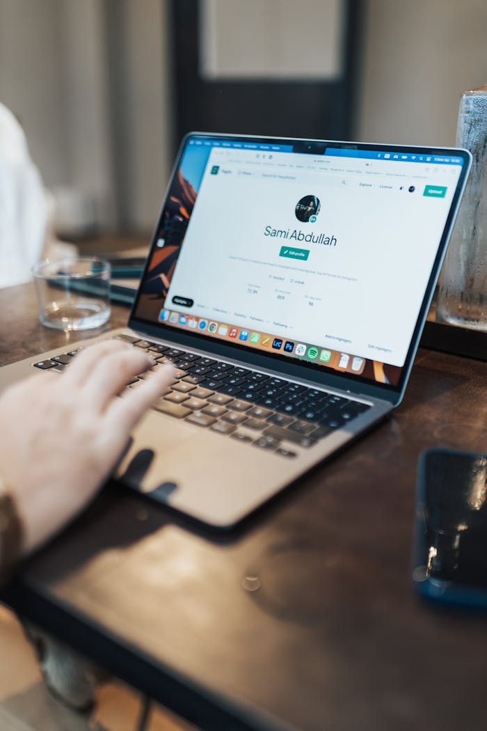 gallery-1 A focused shot of a person using a laptop indoors, highlighting device interaction.